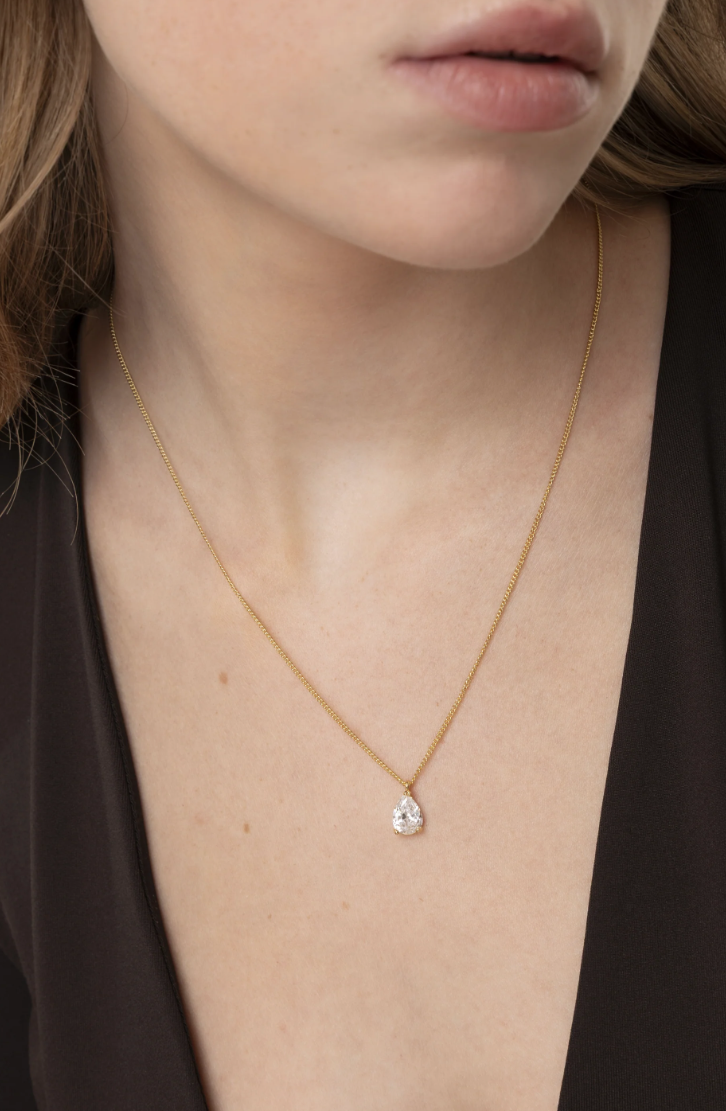 Collana corta con solitario a goccia e chiusura a moschettone regolabile. Nickel tested. Lega di zinco placcata oro con zirconi. Nickel tested.